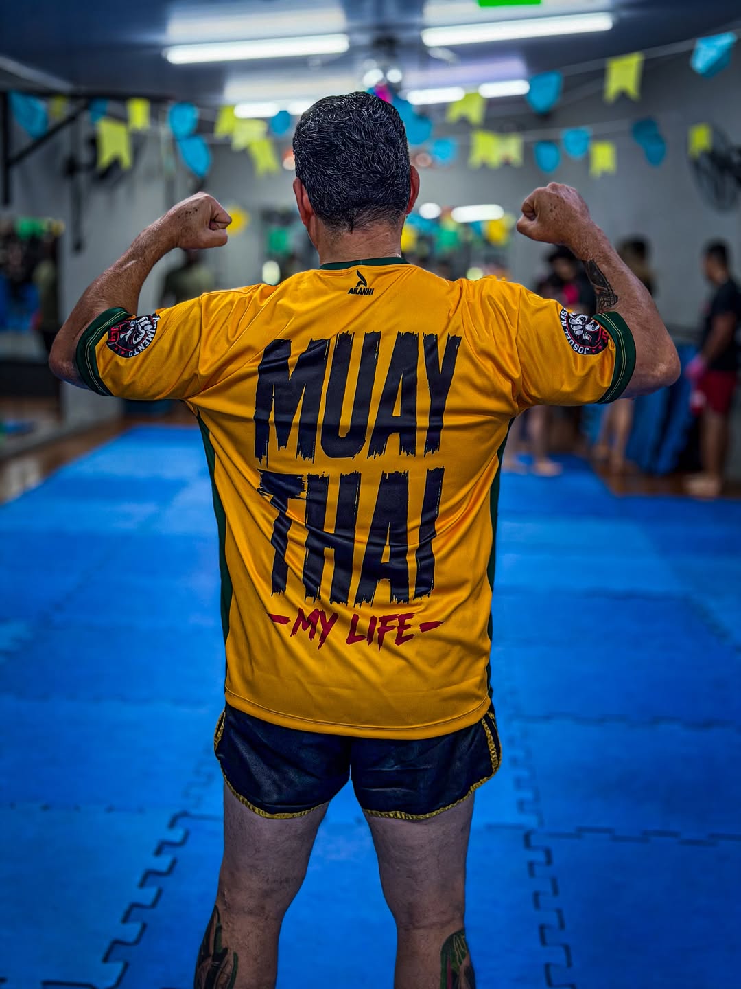 Josuel Nascimento mostrando uniforme de Muay Thai produzido pela Akanni